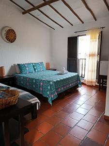 1 dormitorio con cama, mesa y ventana en Hotel Campestre Casona del Camino Real, en San Gil