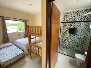 a bedroom with a bunk bed and a bathroom at CASA BRISA MAR DELUXE - Maragogi in Maragogi
