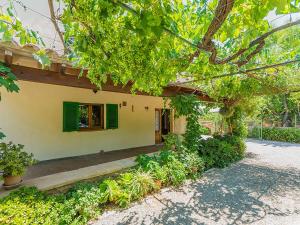 a house with green shutters and a window at Holiday Home Cuxach d'en Joan by Interhome in Pollença