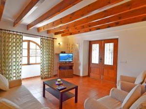 a living room with a couch and a tv at Holiday Home Cuxach d'en Joan by Interhome in Pollença