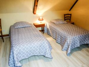 a bedroom with two beds and a table with a lamp at Holiday Home Le Champ du Lac by Interhome in Salviac