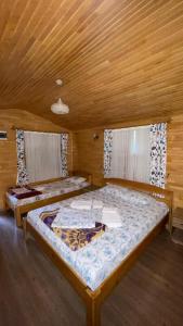 a bedroom with two beds in a wooden room at Olympos Varuna Bungalows in Olympos