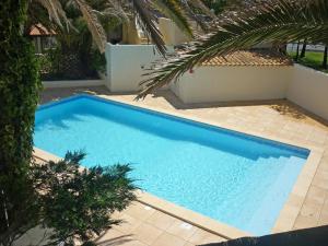 ein großer blauer Pool neben einem Haus in der Unterkunft Apartment Le Florid-3 by Interhome in Cap d'Agde