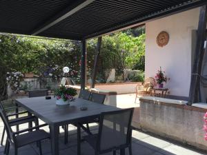 un tavolo e sedie su un patio con tavolo e sedie di holidaysora Taormina - il giardino di Graziella a Taormina