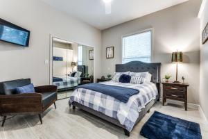a bedroom with a bed and a chair and a mirror at 4-BR Waterfront - Pool Kayak Paddleboard & More in Lakewood Village +32 photos
