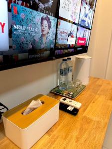 a wooden table with a remote control and a box at Pk house and cosy - Sala201 in Betong