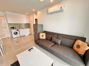 a living room with a couch and a table at CORNER 1 Bedroom Condo in Amazon Residence in Jomtien Beach