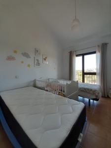a bedroom with a bed and a crib in it at Valle Verde Alcaidesa in San Roque