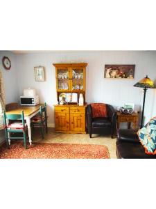 a living room with a table and a chair and a couch at Cliff View Lodge Apartment in Liscannor
