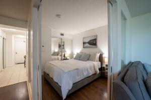 1 dormitorio con cama y espejo en Fort York Apartments en Toronto