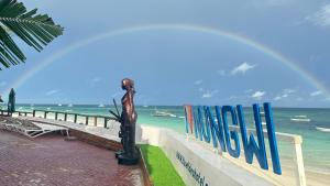 un puente sobre el océano con un arco iris en el cielo en Blue Tides Hotel en Nungwi