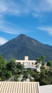 a mountain with a white building in front of it at Acomodação Cambirela in Palhoça