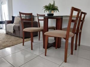 a dining room table with four chairs and a couch at APARTAMENTO EM GARANHUNS PERTO De TUDO in Garanhuns