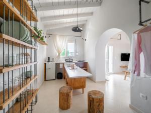 a kitchen with white walls and a table and some logs at The Cottage in Petrití