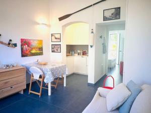 Una sala de estar con una mesa y una cocina. en Casa Marina, en Tellaro