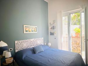 Un dormitorio con una cama azul y una ventana. en Casa Marina, en Tellaro