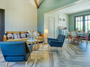 a living room with blue chairs and a couch at Holiday Home La Cabane Andernosienne by Interhome in Andernos-les-Bains