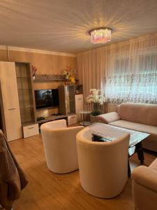 a living room with a couch and a table and chairs at Apartment Deluxe Holiday in Bihać