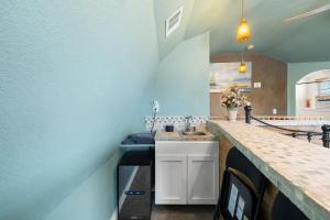 a kitchen with blue walls and a counter with a sink at Entire 2br 2ba hilltop view home Sleeps 8 pets 4 acres Jacuzzi Central AC Kingbeds Free Wifi-Parking Kitchen WasherDryer Starry Terrace Two Sunset Dining Patios Grill Stovetop Oven Fridge OnsiteWoodedHiking Wildlife CoveredPatio4pets & Birds Singing! in Marble Falls +37 photos