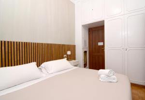 1 dormitorio con 1 cama blanca y 2 toallas en B&B Casa Cimabue Roma en Roma