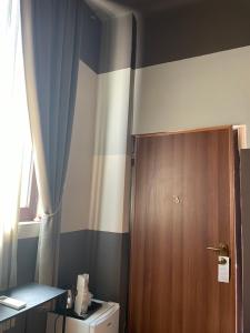 baño con puerta de madera y aseo en Villa Tower Inn, en Pisa