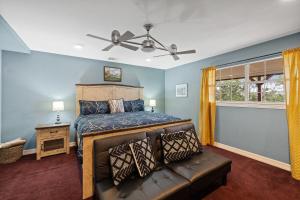 a bedroom with a bed and a couch at Entire 2br 2ba hilltop view home Sleeps 8 pets 4 acres Jacuzzi Central AC Kingbeds Free Wifi-Parking Kitchen WasherDryer Starry Terrace Two Sunset Dining Patios Grill Stovetop Oven Fridge OnsiteWoodedHiking Wildlife CoveredPatio4pets & Birds Singing! in Marble Falls
