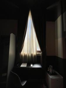 een raam met een gordijn in een kamer bij Villa Tower Inn in Pisa