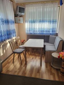 a living room with a couch and a table and chairs at Apartment Deluxe Holiday in Bihać +4 photos
