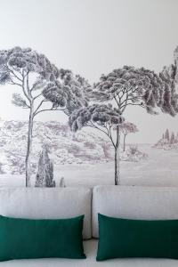 a couch in a room with trees on a wall at La Garoupe-Gardiole in Antibes