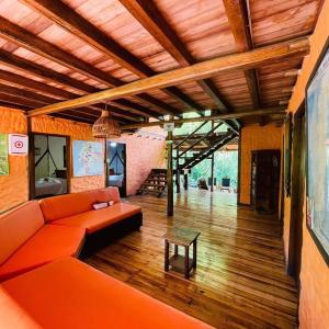 a living room with an orange couch and a table at Cabañas Bambu Mindo in Mindo