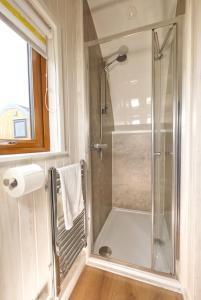 a bathroom with a shower with a glass door at North Coast 500 Pods - Brora in Brora