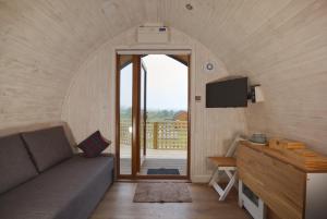 a small living room with a couch and a tv at North Coast 500 Pods - Brora in Brora