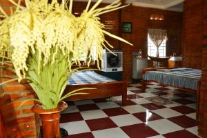 una camera con un letto e un pavimento a scacchi di BOSA Homestay - Mekong Riverside a Can Tho