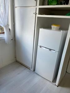 una nevera blanca en una cocina con puerta abierta en gms service, en Lorenskog