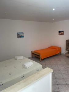 a bedroom with two beds and an orange mattress at Lungomare Elio Vittorini in Siracusa