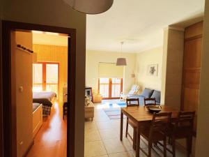 a living room with a table and a dining room at Casa da Serra - T1 - Penhas da Saúde in Penhas da Saúde