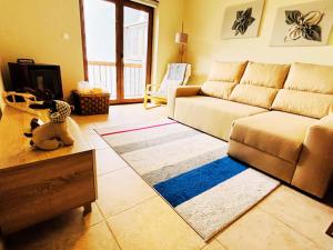 sala de estar con sofá y alfombra en Casa da Serra - T1 - Penhas da Saúde en Penhas da Saúde