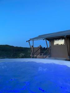 a view of a swimming pool with a house at Ecosse Glamping in Crossford