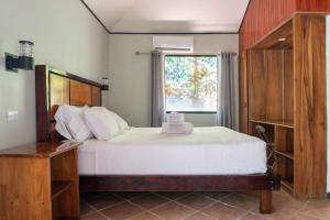 a bedroom with a large bed and a window at Bongo - Adults Only in Manuel Antonio