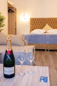 een fles champagne en twee glazen op een tafel bij Serenity Luxe Suites in Parga