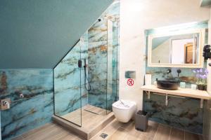 e bagno con doccia, servizi igienici e lavandino. di Serenity Luxe Suites a Párga Altre 37 foto