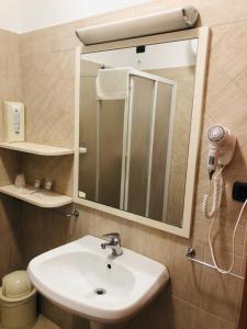 een badkamer met een wastafel en een spiegel bij Hotel Softwood in Recanati