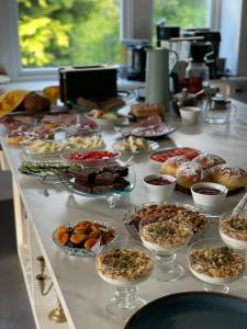 ein Buffet mit vielen verschiedenen Speisen auf dem Tisch in der Unterkunft Fjord House in Grimo