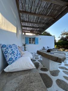 a patio with a bench and pillows on it at Louloudasrooms Studio in Molos Parou