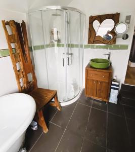 Pond Cottage في بورلي: حمام مع دش وحوض استحمام ومغسلة