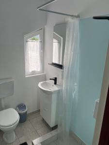 a white bathroom with a sink and a toilet at Sale&Pepe in Faraoaní