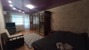 um quarto com uma cama, uma cadeira e uma televisão em Однокімнатна квартира на вулиці Володимира Великого 22 em Kryvyi Rih