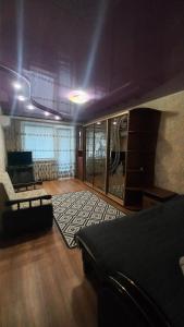 uma sala de estar com um sofá e um quarto com uma mesa em Однокімнатна квартира на вулиці Володимира Великого 22 em Kryvyi Rih