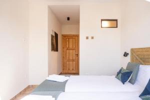 1 dormitorio con 2 camas y puerta de madera en Complejo Rural en Porcuna-Jaén en Porcuna