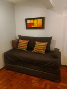 - un canapé noir avec trois oreillers dans le salon dans l'établissement Nueva Cordoba Funcional, à Córdoba
